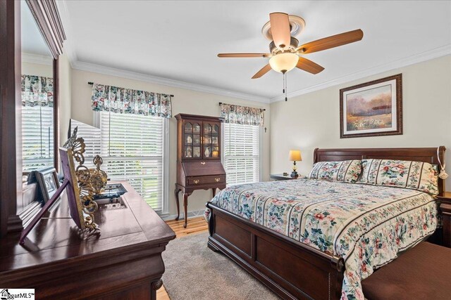 bedroom featuring ornamental molding, light wood-style floors, and ceiling fan