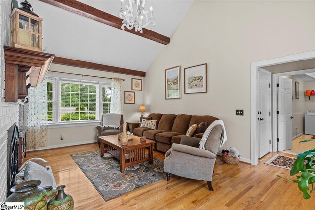 living area with a fireplace, beam ceiling, a chandelier, baseboards, and light wood-type flooring