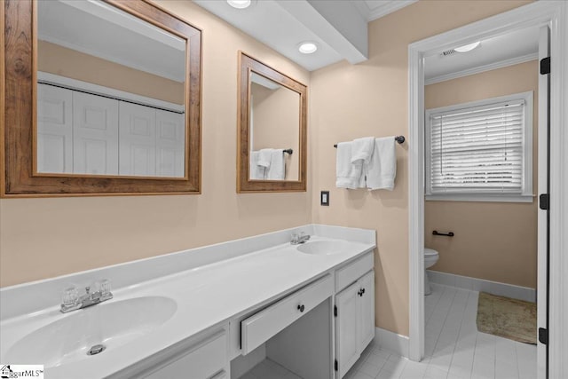 full bath featuring double vanity, baseboards, toilet, and crown molding