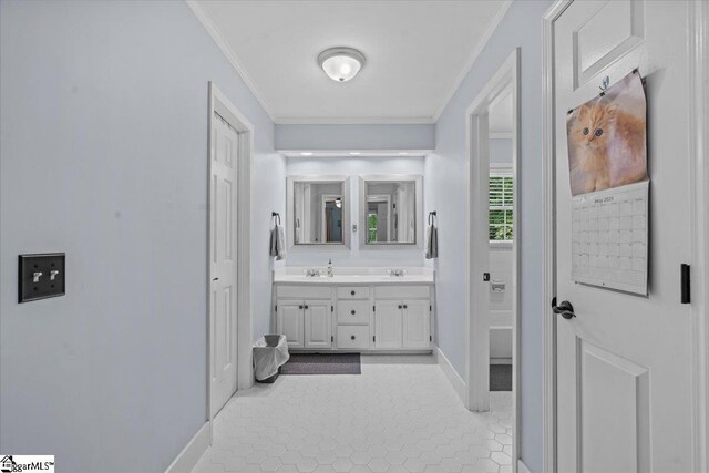 full bath featuring crown molding, baseboards, double vanity, and tile patterned flooring