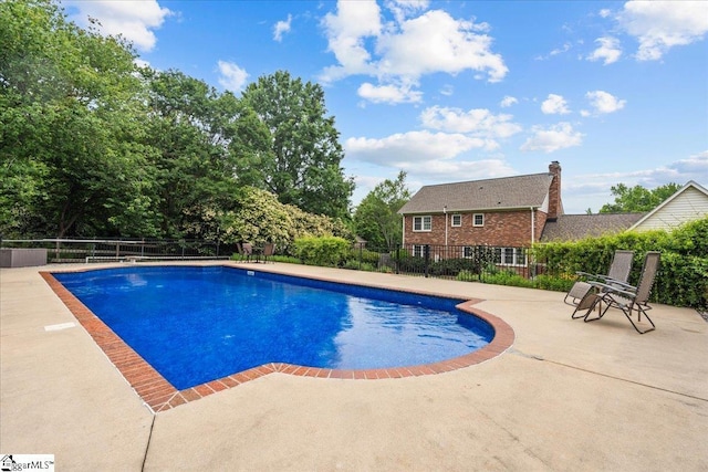 view of swimming pool featuring fence and a patio area
