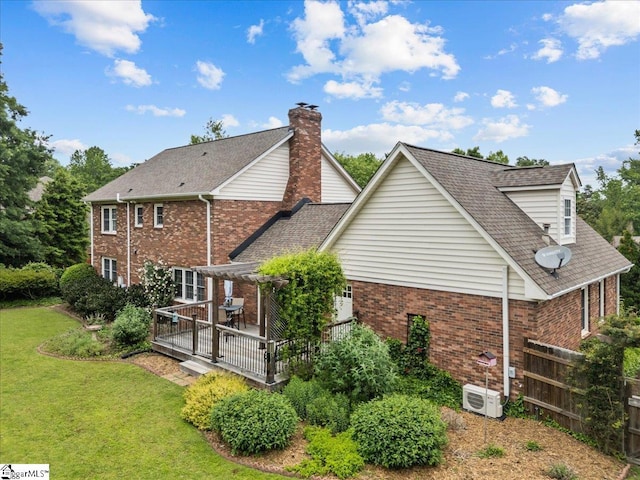 rear view of property featuring brick siding, a cooling unit, a lawn, a shingled roof, and a wooden deck