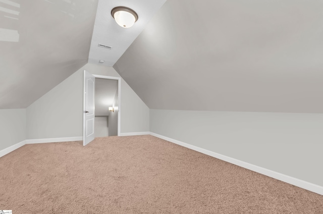 additional living space with carpet flooring, baseboards, and lofted ceiling