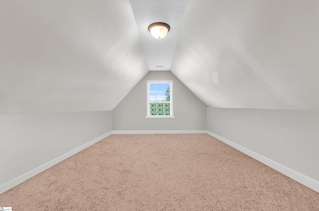 bonus room with lofted ceiling, baseboards, and carpet flooring