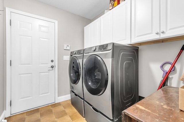 laundry area with washing machine and dryer, cabinet space, and baseboards