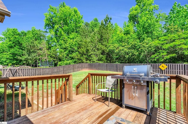 wooden deck with grilling area and view of scattered trees