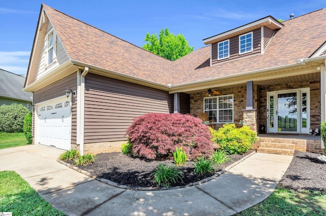 view of front of house with a shingled roof, a porch, driveway, and a garage