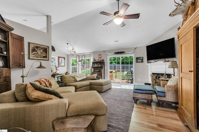 living room with lofted ceiling, light wood finished floors, and ceiling fan