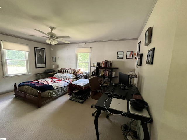 carpeted bedroom with ornamental molding and a ceiling fan