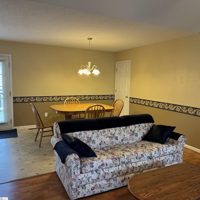living room with a chandelier, baseboards, and wood finished floors