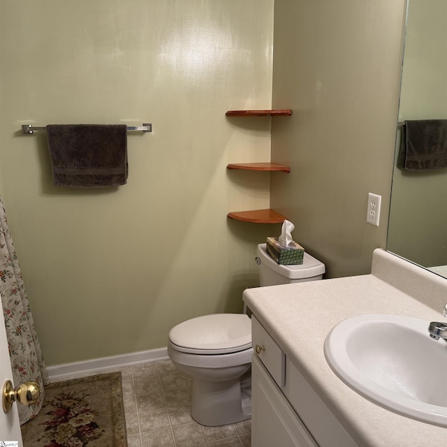 bathroom with toilet, baseboards, vanity, and tile patterned flooring