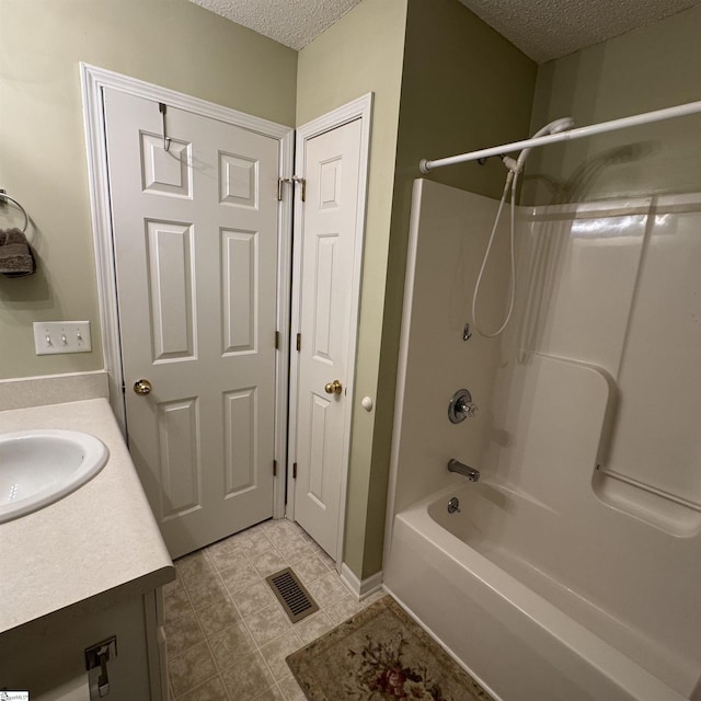 bathroom featuring a textured ceiling, vanity, bathtub / shower combination, and tile patterned floors