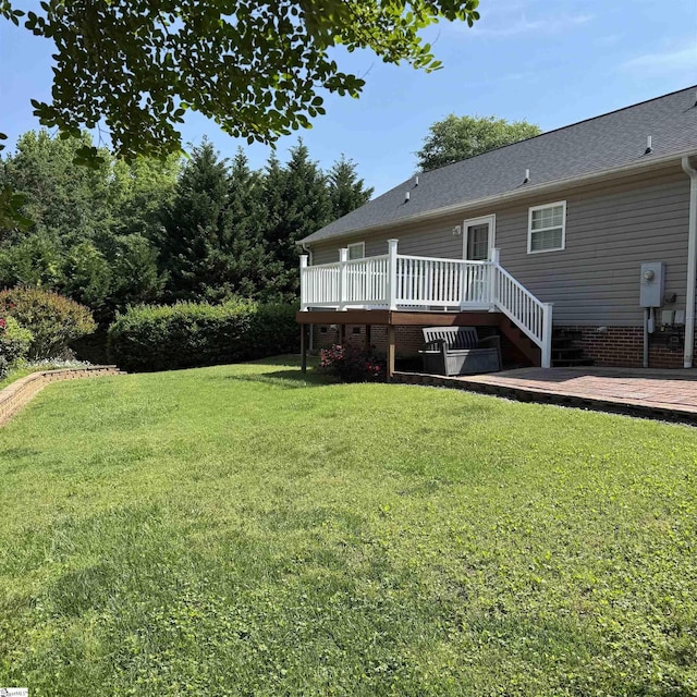 view of grassy yard with a deck
