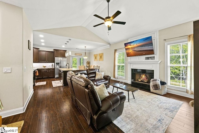 208 Laurel Trace Cir, Piedmont, SC 29673 - living room with ceiling fan, dark wood-type flooring, vaulted ceiling, a warm lit fireplace, and baseboards