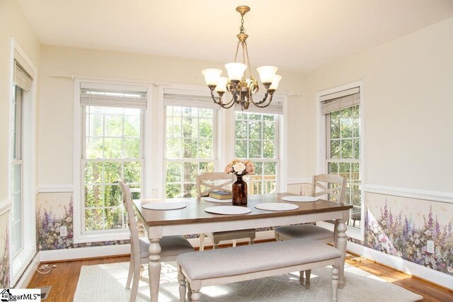 dining space featuring a chandelier, wood finished floors, and baseboards