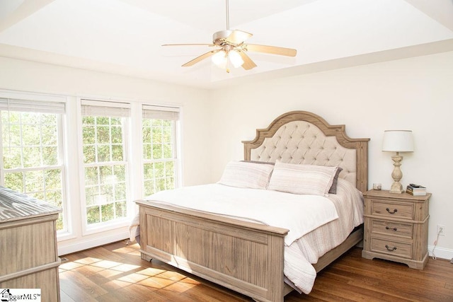 bedroom with multiple windows, wood finished floors, baseboards, and ceiling fan