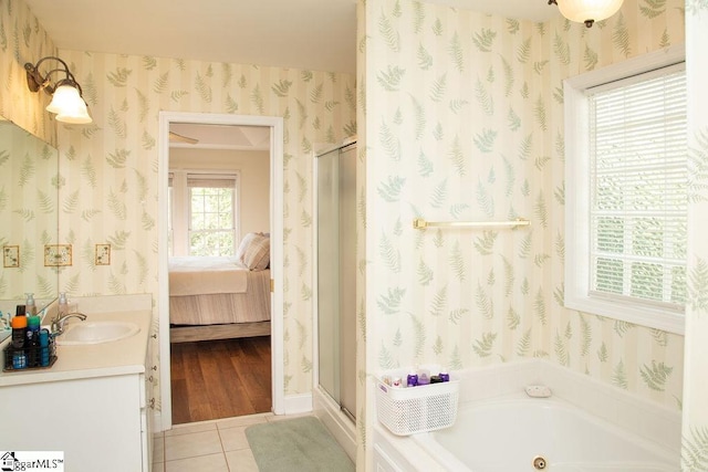 ensuite bathroom featuring wallpapered walls, tile patterned flooring, a shower stall, a tub with jets, and vanity