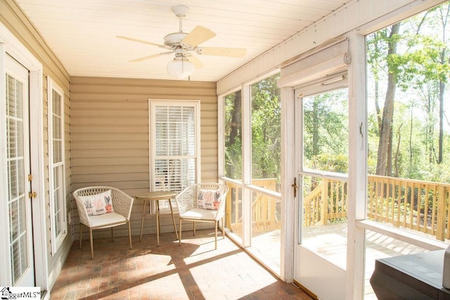 sunroom / solarium featuring a ceiling fan