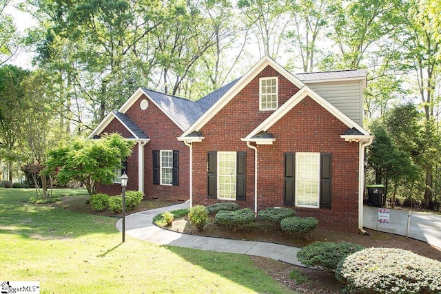 traditional home featuring a front lawn and brick siding