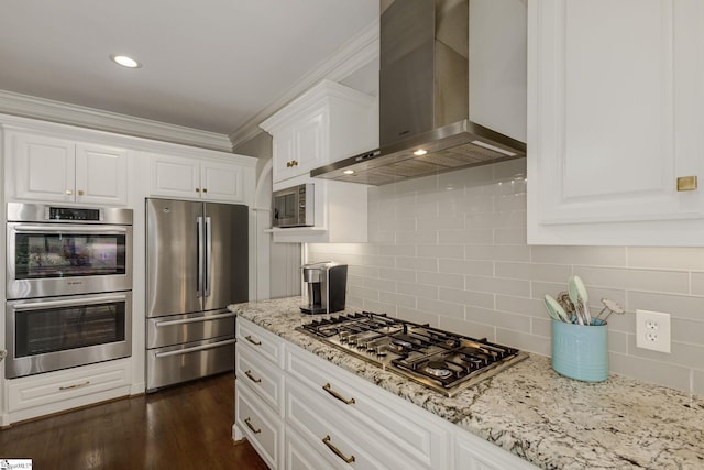 kitchen with appliances with stainless steel finishes, wall chimney range hood, ornamental molding, white cabinets, and light stone countertops