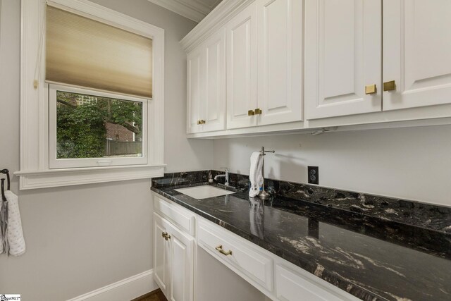 laundry room with a sink and baseboards