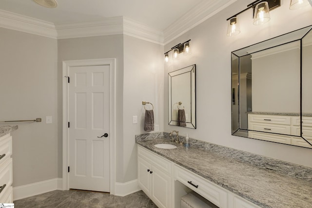 bathroom with vanity, crown molding, and baseboards
