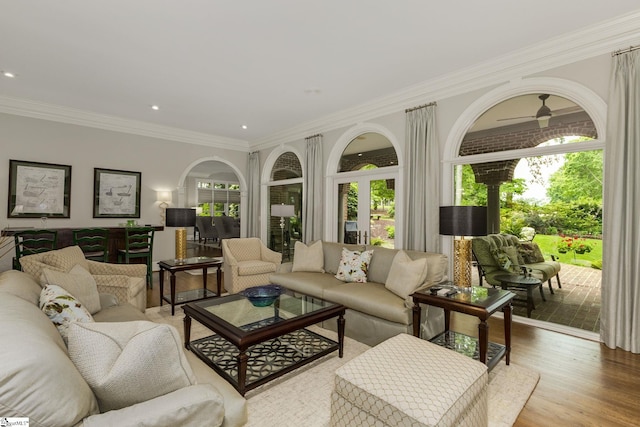 living area with ornamental molding, recessed lighting, light wood-style flooring, and ceiling fan