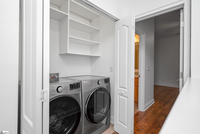 washroom with wood finished floors and washing machine and dryer