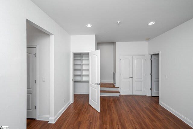 unfurnished bedroom with dark wood-style flooring, baseboards, and recessed lighting