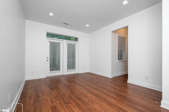 spare room featuring recessed lighting, baseboards, and wood finished floors