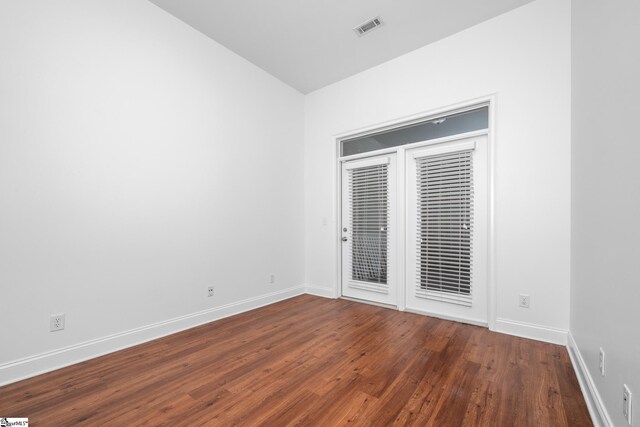 spare room featuring wood finished floors and baseboards