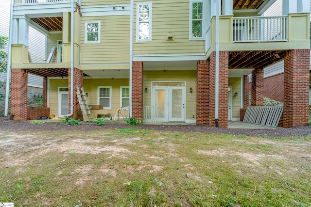 rear view of house featuring a balcony and brick siding