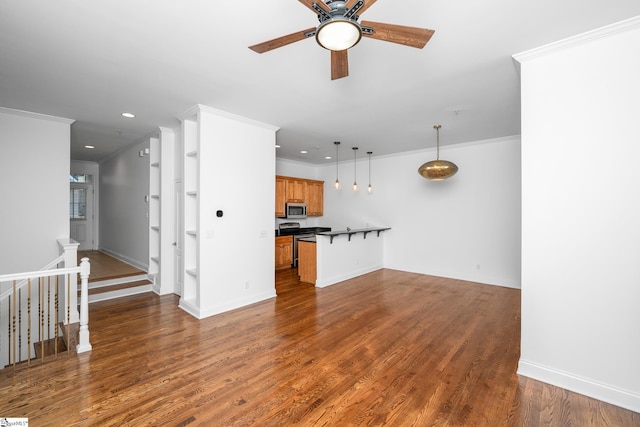 unfurnished living room featuring a ceiling fan, recessed lighting, wood finished floors, crown molding, and baseboards
