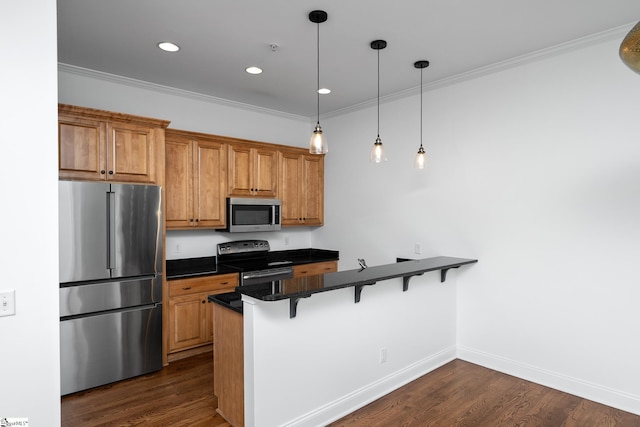 kitchen featuring stainless steel appliances, a peninsula, a breakfast bar area, brown cabinets, and crown molding