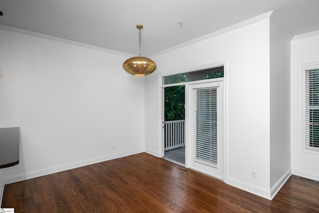 empty room featuring crown molding, wood finished floors, and baseboards