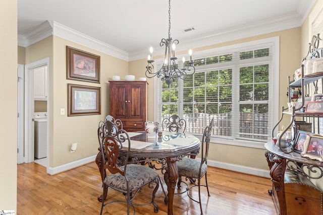 1008 Calumet Ct, Piedmont, SC 29673 - dining area with baseboards, a chandelier, washer / clothes dryer, ornamental molding, and light wood finished floors