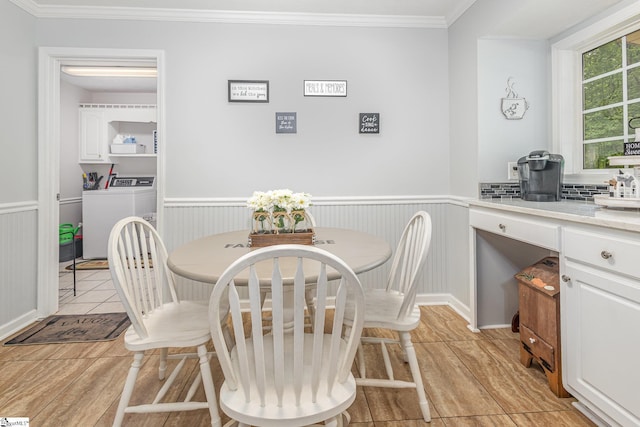 108 Ascot Ct, Easley, SC 29642 - dining room with light wood-style flooring, crown molding, independent washer and dryer, and a wainscoted wall