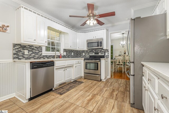 108 Ascot Ct, Easley, SC 29642 - kitchen featuring appliances with stainless steel finishes, tasteful backsplash, white cabinets, a sink, and ornamental molding