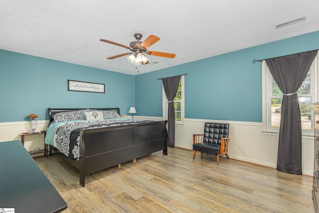 108 Ascot Ct, Easley, SC 29642 - bedroom featuring wainscoting, wood finished floors, multiple windows, ceiling fan, and a textured ceiling