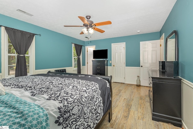 108 Ascot Ct, Easley, SC 29642 - bedroom featuring wood finished floors, multiple windows, wainscoting, and ceiling fan