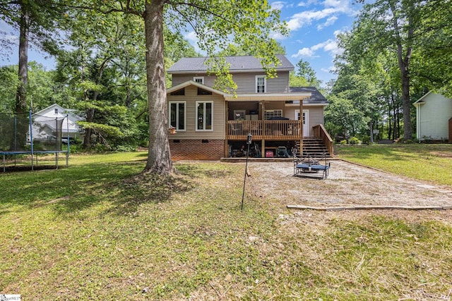 108 Ascot Ct, Easley, SC 29642 - rear view of house featuring a trampoline, a wooden deck, a fire pit, a lawn, and crawl space