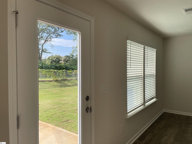 doorway featuring baseboards and wood finished floors
