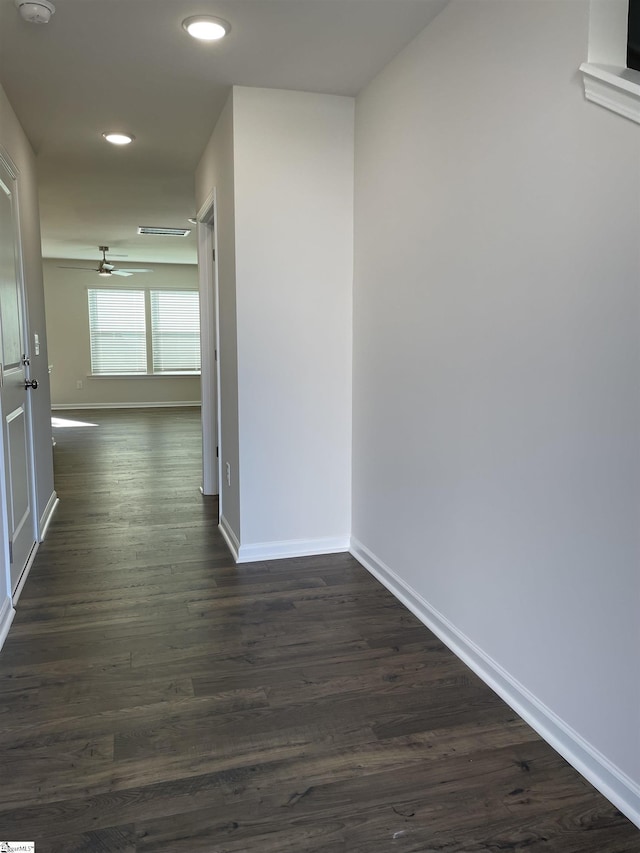 hallway with recessed lighting, baseboards, and dark wood-type flooring