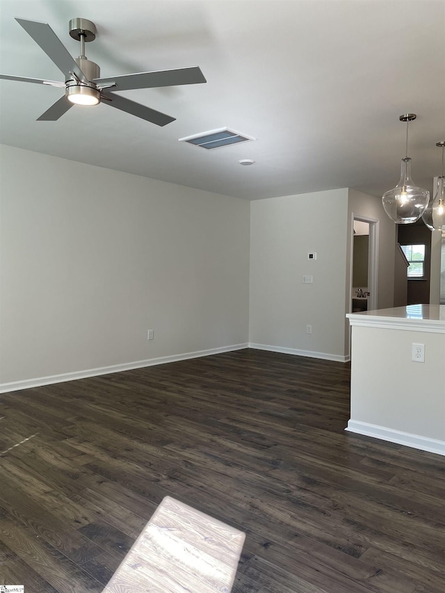 unfurnished living room featuring dark wood-style floors, baseboards, and ceiling fan