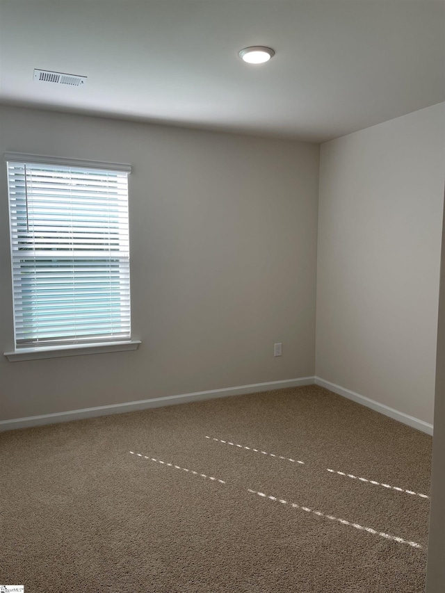 spare room featuring baseboards and carpet