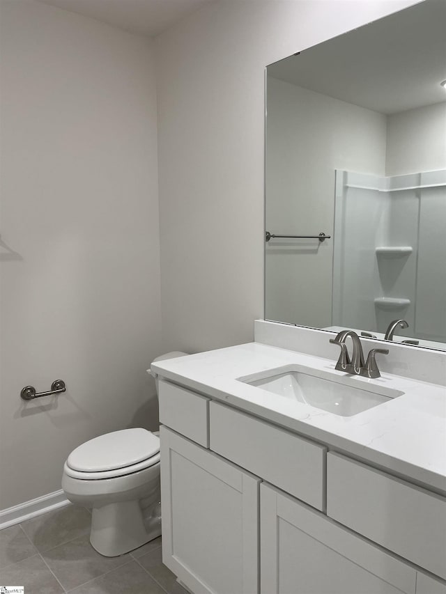 bathroom featuring toilet, vanity, tile patterned flooring, and baseboards