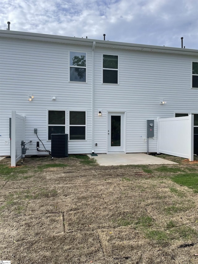 rear view of house featuring a patio area, cooling unit, and a lawn