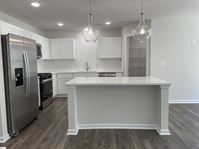 kitchen with appliances with stainless steel finishes, a sink, light countertops, white cabinets, and recessed lighting