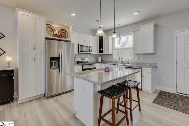 kitchen with appliances with stainless steel finishes, light wood-style flooring, white cabinets, and recessed lighting