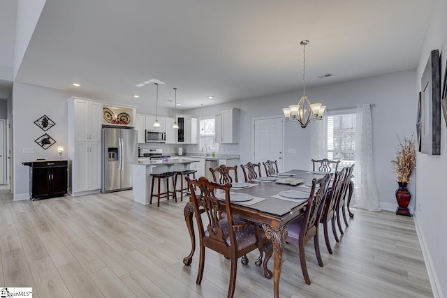 dining area featuring light wood-style flooring, a chandelier, baseboards, and recessed lighting